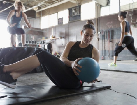 Three woman performing different exercises in a gym