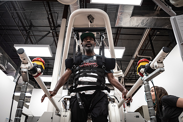 A man uses assistive technology to stand and walk