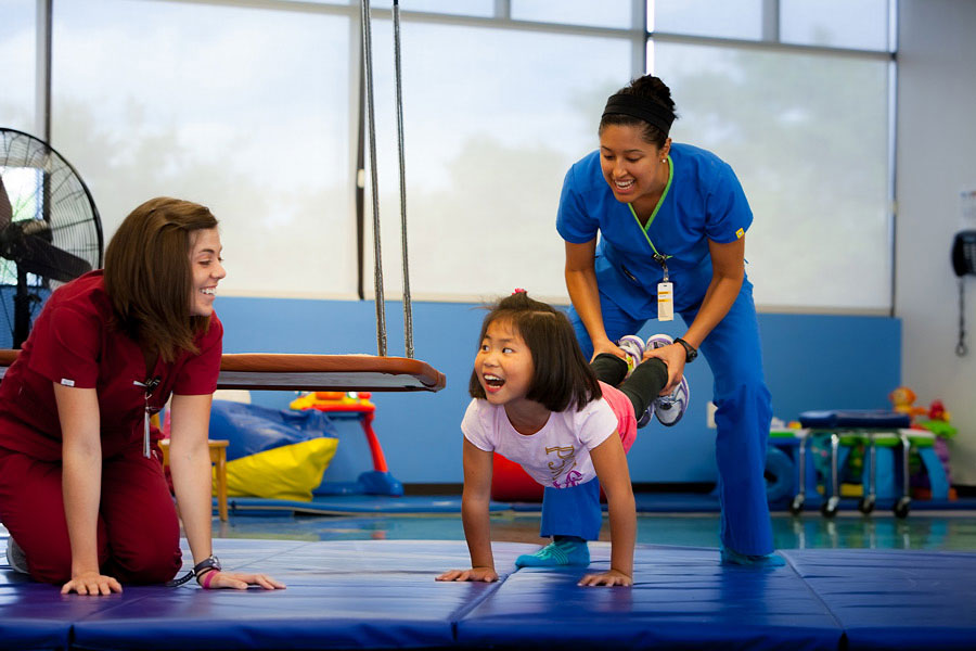 Girl participating in rehabilitation with therapists