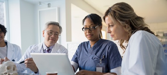 Physicians and residents looking at computer