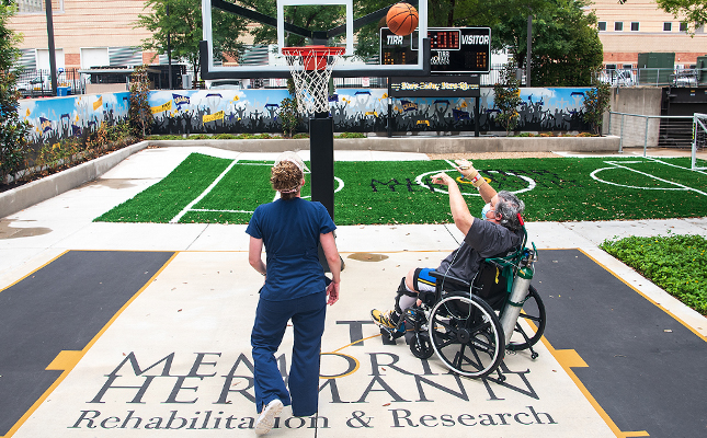 A TIRR Memorial Hermann patient and therapist play basketball as a means of rehabilitation