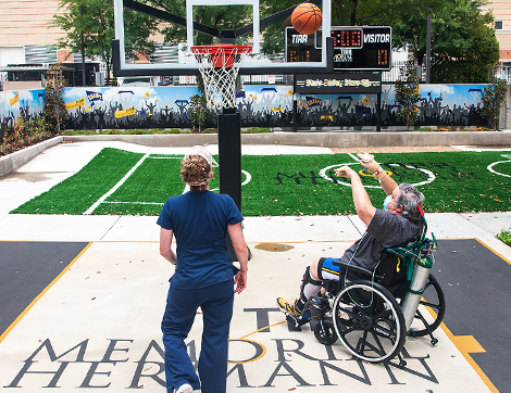 A TIRR Memorial Hermann patient and therapist play basketball as a means of rehabilitation