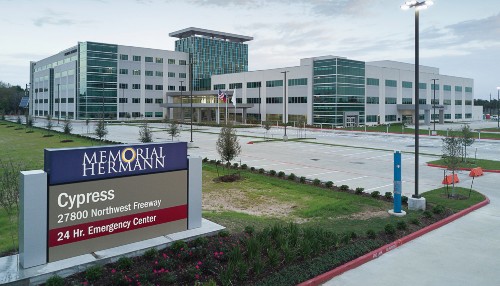 The Memorial Hermann Cypress Hospital campus signage with the hospital in the background.