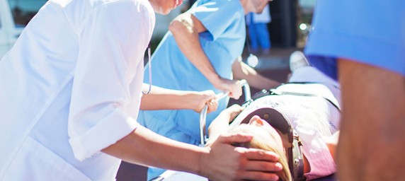 Doctor comforting patient on stretcher outside of hospital