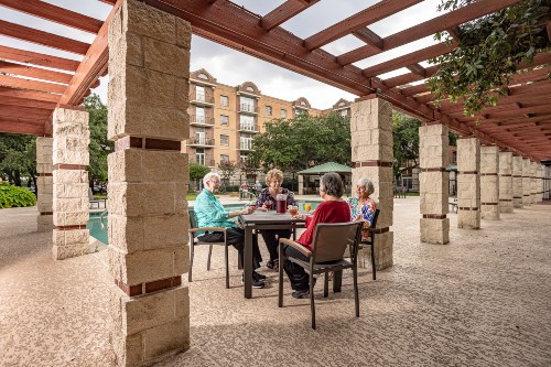 Residence of Memorial Hermann University Place sit together poolside.